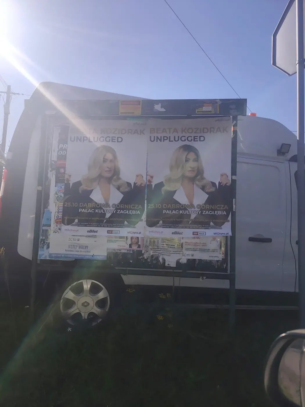 Dwa plakaty Beata Kozidrak Unplugged na tablicy ogłoszeniowej przy zaparkowanym samochodzie w Jaworznie