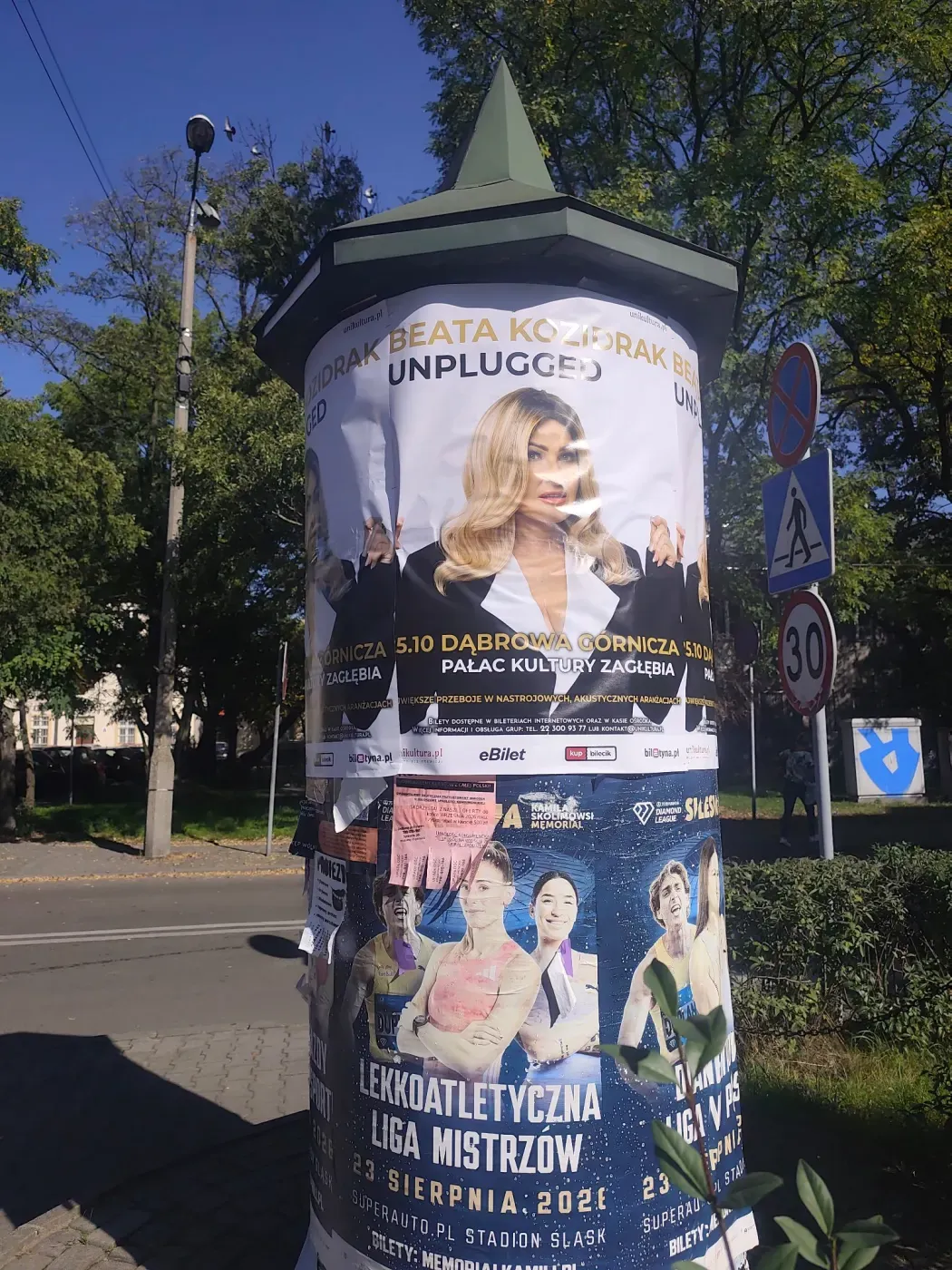 Plakat Beata Kozidrak Unplugged na słupie ogłoszeniowym przy chodniku w Jaworznie