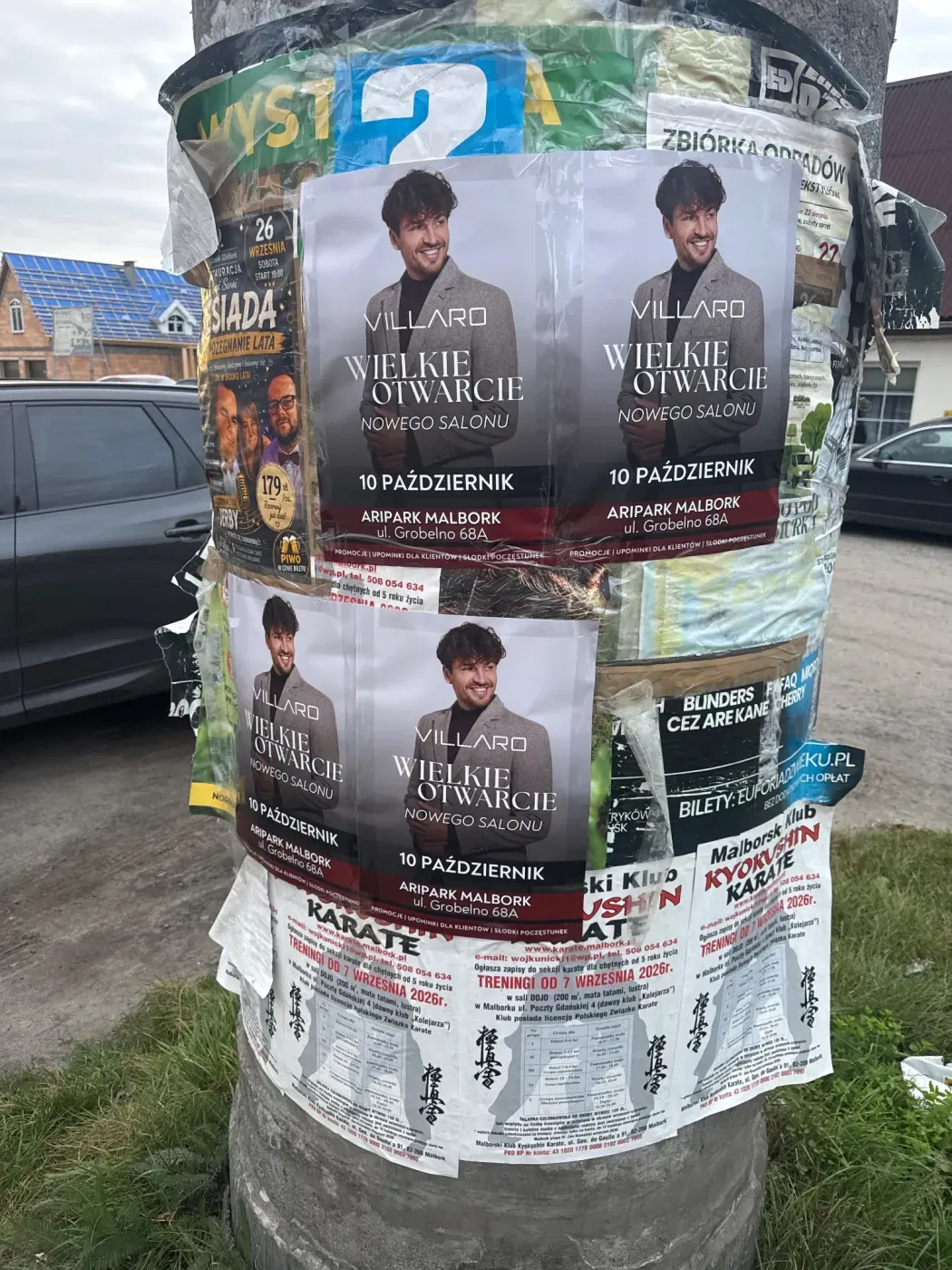 Cztery plakaty Wielkie Otwarcie VILLARO na słupie ogłoszeniowym obok ulicy