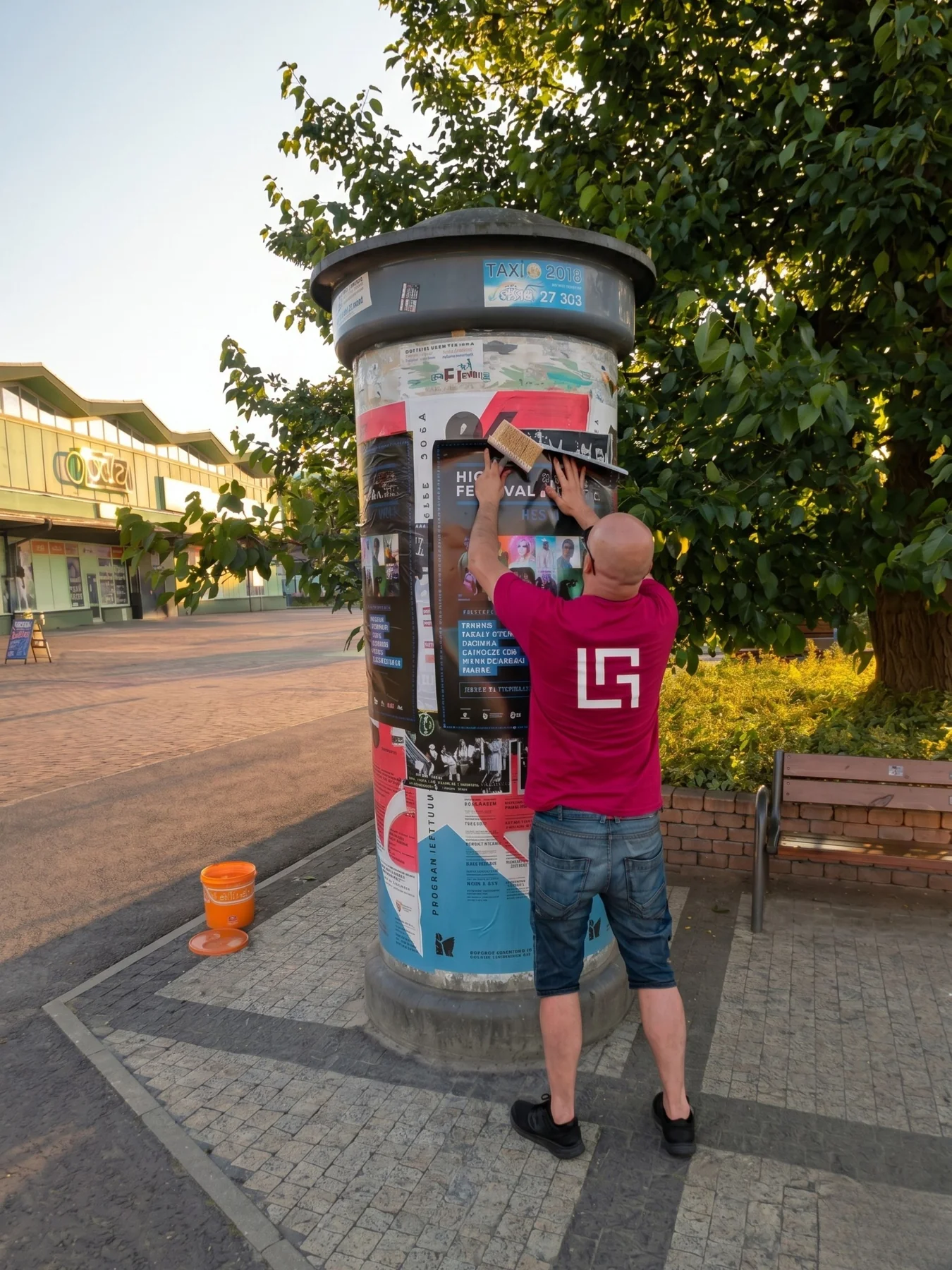 Lokalna ekipa rozwieszająca plakaty na słupie reklamowym w Płocku